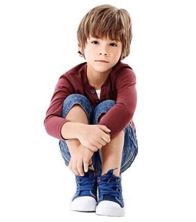 Young boy crouched with arms crossed over his knees